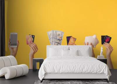 Female hands with money, credit cards, piggy bank and mobile phone on color background. Concept of online banking Wall mural