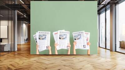 Female hands with newspapers on color background Wall mural