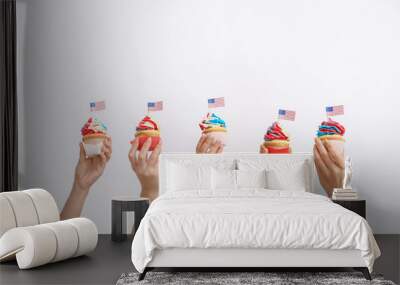 Female hands with tasty patriotic cupcakes on white background Wall mural