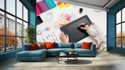 Female interior designer working with graphic tablet at table in office, top view Wall mural