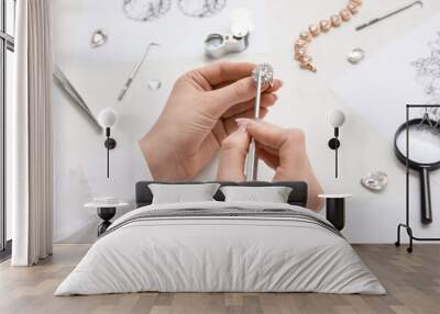 Female jeweler making ring on white table, closeup Wall mural