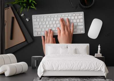 Female programmer using computer keyboard with mouse, notebooks and stationery on dark background Wall mural