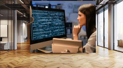 Female programmer working with computer in office at night Wall mural