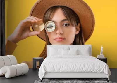 Female tourist with compass on yellow background, closeup Wall mural