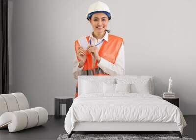 Female worker in vest and with badge on light background Wall mural