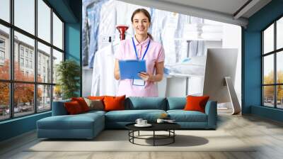 Female worker of modern dry-cleaner's at reception Wall mural