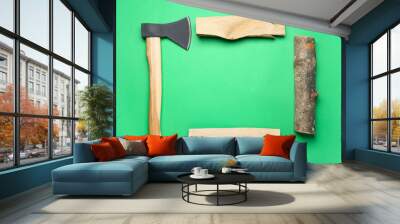 Frame made of ax and firewood on green background Wall mural