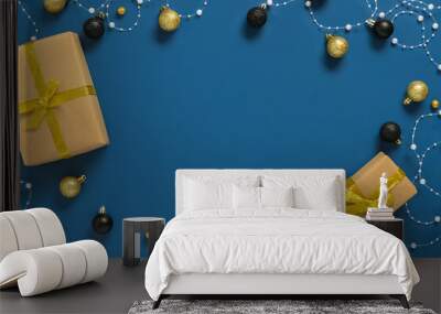 Frame made of yellow gift boxes and Christmas balls on blue background Wall mural