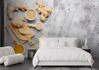 Fresh ginger roots, bowl and wooden spoon with dried powder on blue background Wall mural