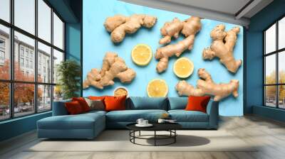 Fresh ginger roots, slices of lemon and bowl of dried powder on blue background Wall mural