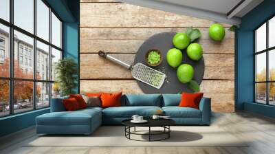 Fresh limes with grater on wooden background Wall mural