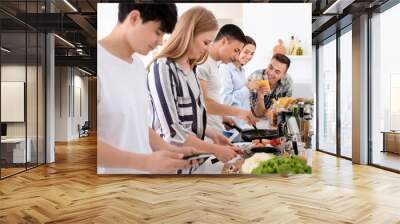 Friends cooking together in kitchen Wall mural