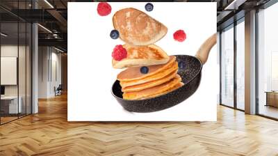 Frying pan with flying pancakes on white background Wall mural