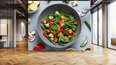 Frying pan with fresh vegetables on grey background Wall mural