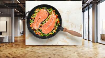 Frying pan with raw salmon steaks and vegetables on table Wall mural