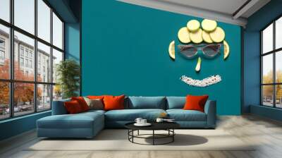 Funny face made of fresh vegetables, sea salt and sunglasses on color background Wall mural