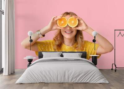 Funny mature woman with cut orange on color background Wall mural