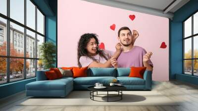 Funny young couple with paper hearts for Valentine's day on pink background Wall mural