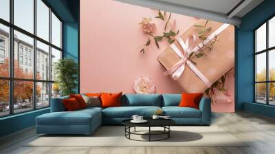 Gift box and beautiful flowers on color background Wall mural