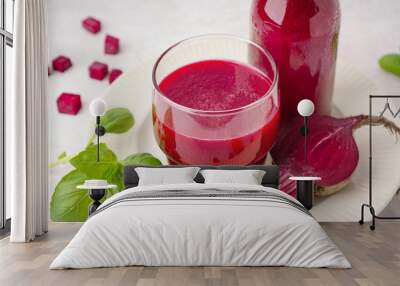 Glass and bottle of fresh beetroot juice on light background Wall mural