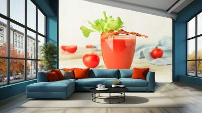 Glass of bloody mary cocktail garnished with bacon and tomatoes on light background Wall mural