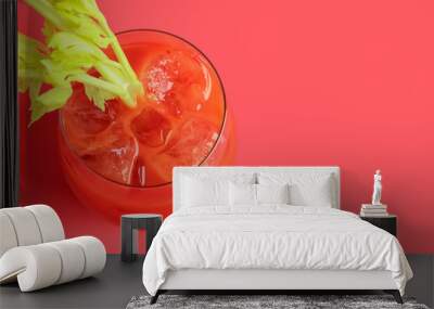 Glass of bloody mary with celery on red background Wall mural