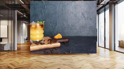 Glass of cold orange espresso on dark blue background Wall mural