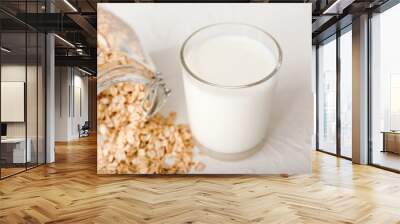 Glass of tasty oat milk on white background Wall mural