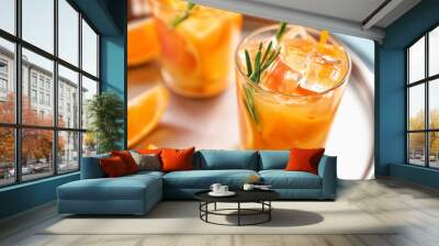 Glass of tasty orange cocktail on tray Wall mural