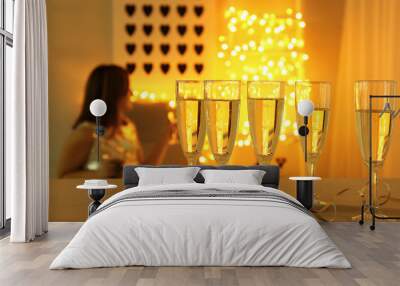 Glasses of champagne on light table in room Wall mural