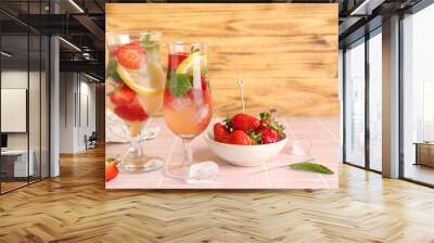 Glasses of fresh lemonade with strawberry and lemon on pink tile table Wall mural