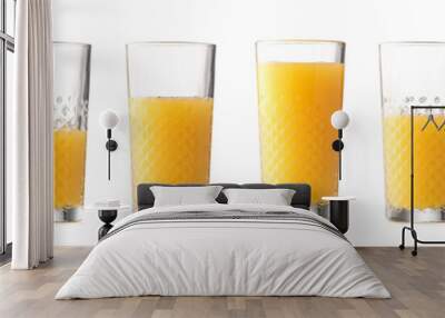 Glasses with different amount of orange juice on white background Wall mural