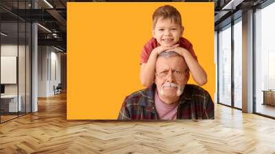 Grandfather with his happy cute little grandson on yellow background Wall mural