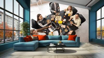 Group of business people having lunch at table in office, top view Wall mural