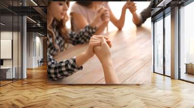 Group of people praying at table Wall mural