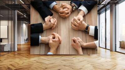 Group of people praying before meeting in office Wall mural