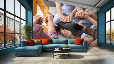 Group of people praying with Holy Bible on floor, closeup Wall mural