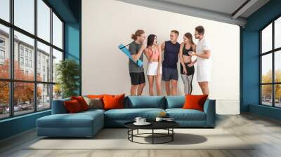 Group of sporty friends near white wall Wall mural