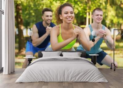 Group of young sporty people training together outdoors Wall mural