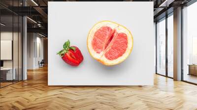 Half of grapefruit with strawberry on light background. Sex concept Wall mural