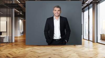 Handsome confident businessman on grey background Wall mural