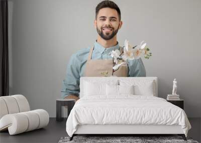 Handsome male florist on light background Wall mural