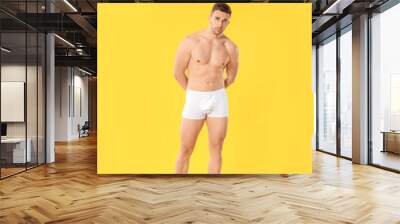 Handsome man in underwear on color background Wall mural