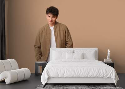 Handsome young man in stylish clothes on brown background Wall mural