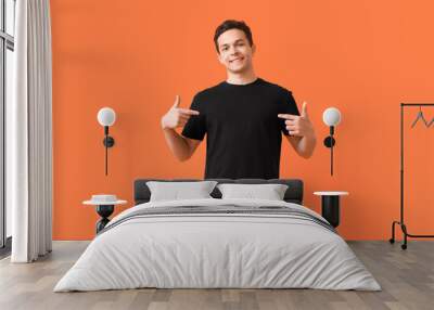 Handsome young man in stylish t-shirt on color background Wall mural