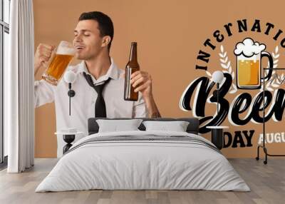 Handsome young man with bottle and mug of beer on brown background. Banner for International Beer Day Wall mural