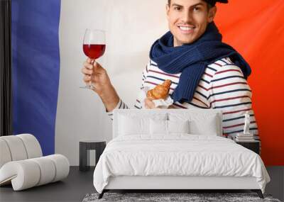 Handsome young man with wine and croissants against flag of France Wall mural