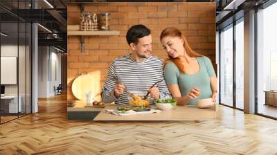 Happy couple cooking together in kitchen Wall mural