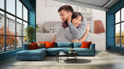 Happy couple hugging after quarrel at home Wall mural