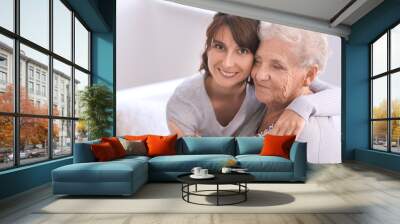 Happy elderly woman with her daughter at home Wall mural